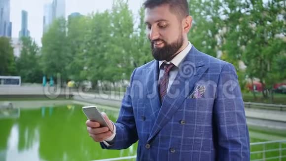 商人在智能手机上聊天站在湖边视频的预览图