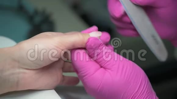 美甲美容师用指甲锉将客户指甲涂在上面视频的预览图