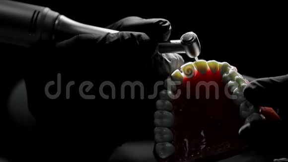 一个牙医的特写练习用钻床模拟牙齿骨架牙医巧妙地练习视频的预览图