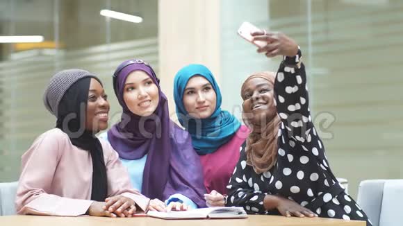 穆斯林多种族学生女孩在大学大厅自拍头巾视频的预览图