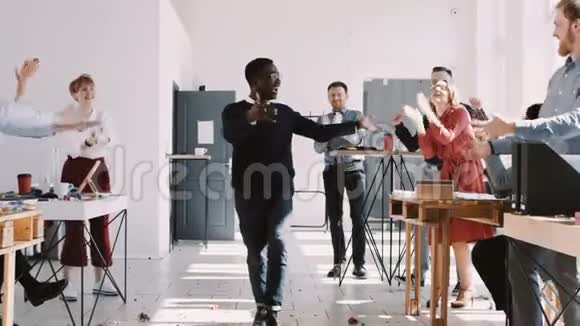 快乐有趣的千禧非洲男性经理庆祝办公室事业成功与有趣的舞蹈慢动作红色EPICW视频的预览图