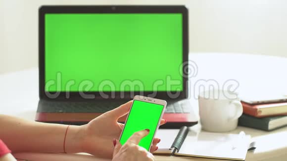 特写女性坐桌笔记本女性手键盘笔记本电脑使用短信指向网络绿色屏幕视频的预览图