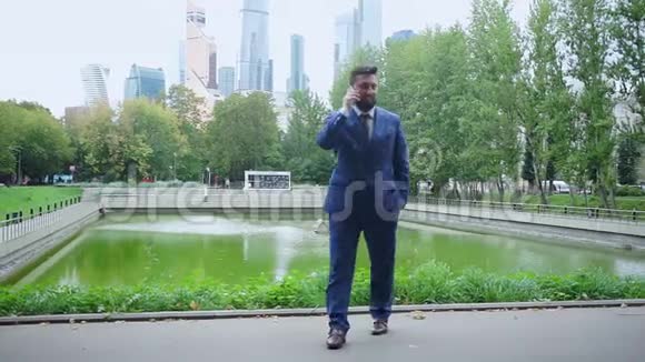 穿格子西装的自信男人在智能手机上讲话视频的预览图