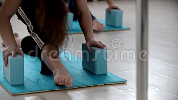 在瑜伽垫上做健身运动双手靠在砖头上视频的预览图