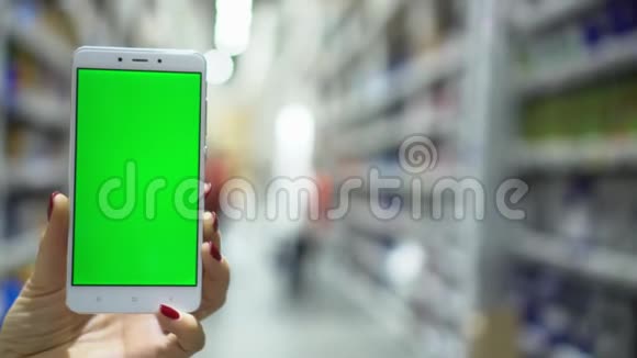Pov女性手提智能手机带着空白绿色屏幕在购物中心散步视频的预览图