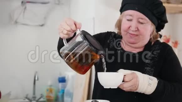 一位老太太在杯子里倒茶视频的预览图