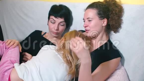 LGBT概念两个母亲和一个女儿躺在沙发上视频的预览图