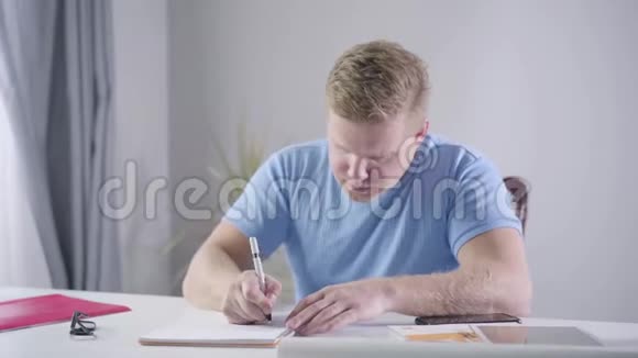 自信的白种人商人坐在桌边做笔记红头发的人在室内思考他的新想法视频的预览图