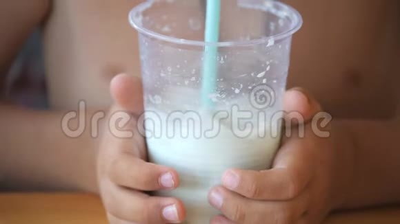 小男孩用吸管喝奶昔孩子吹过管子开始气泡视频的预览图