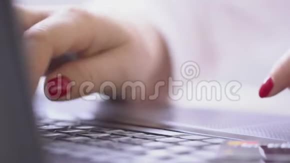 在室内用手提电脑键盘关闭女士的手打字视频的预览图