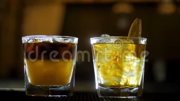 酒保将烈性威士忌倒入酒吧柜台上装有新鲜橙汁的鸡尾酒杯中视频的预览图