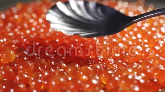 铺红鱼子酱背景是红色鱼子酱勺子把鱼子酱排在盘子里视频的预览图