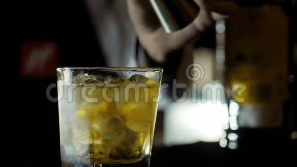 酒吧老板倒威士忌用水晶杯和冰块混合视频的预览图