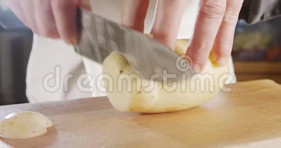 厨师用锋利的大刀切土豆的慢动作视频的预览图