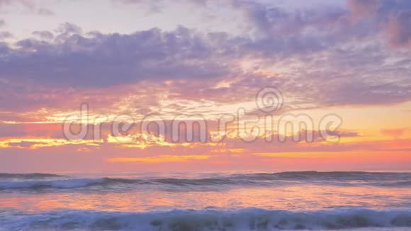 夏日夕阳下的云金色的沙海浪视频的预览图
