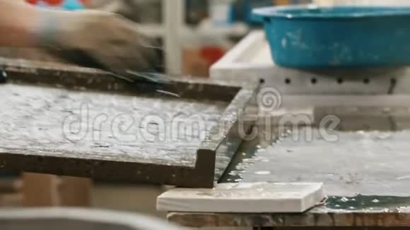 一名工人用抹布和水在车间里洗混凝土板视频的预览图