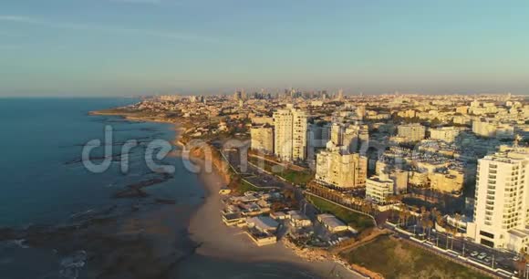 以色列特拉维夫贾法市旁边的一个城市日落或日出期间蝙蝠山海滩和酒店的美丽空中景色视频的预览图