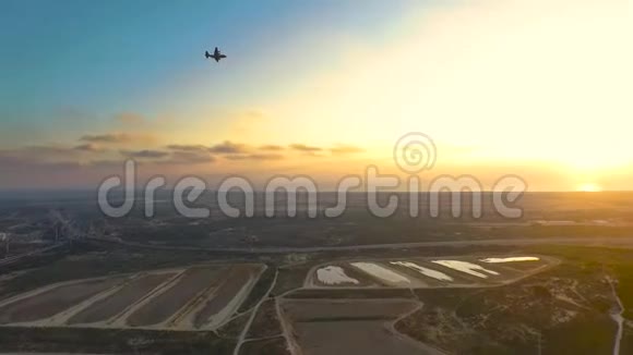 惊人的无人机日落与飞机穿越天空走向日落在开阔的田野和视频的预览图