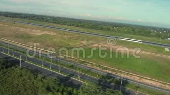 路前往机场附近的田野城市附近的跑道无人机沿空高速公路飞行视频的预览图