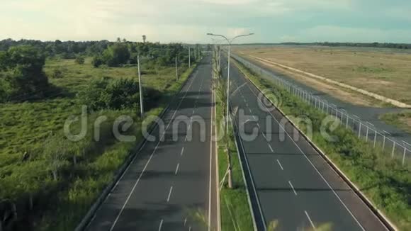 摩托车手骑在高速公路上无人驾驶飞机用棕榈树和运输工具拍摄公路视频的预览图