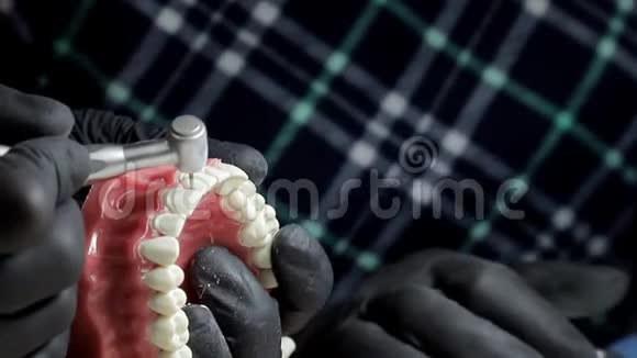 牙科医生戴着黑色手套用钻床完成牙齿骨架的模拟牙医很灵巧视频的预览图
