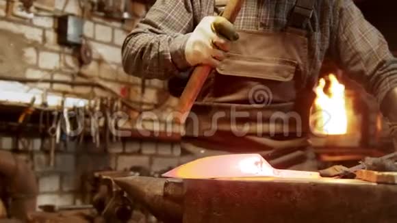 铁匠工人在车间里用铁锻造一把刀视频的预览图
