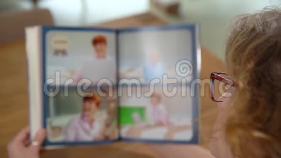 一个女人在看一张带有高中工作室照片的专辑视频的预览图