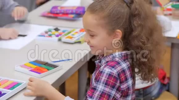 孩子们手特写孩子们用塑料在桌子上雕刻孩子们画的发展圈视频的预览图