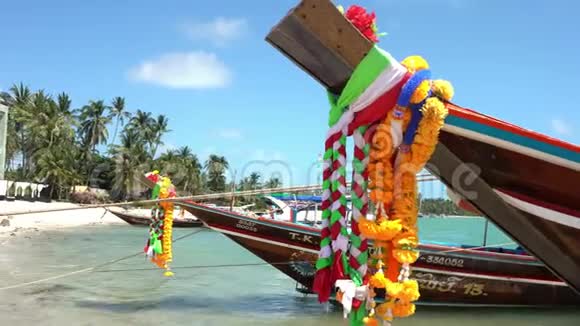传统的泰国船在海边的海水中泰国热带船只装饰着鲜花和丝带视频的预览图