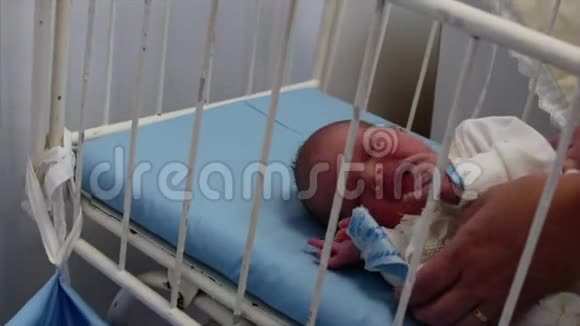 母亲在分娩后从婴儿床上把她的新生儿抱起来新生儿出生后躺在床上概念视频的预览图