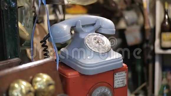 一家跳蚤商店出售蓝色老式旋转拨号电话的多利右拍视频的预览图