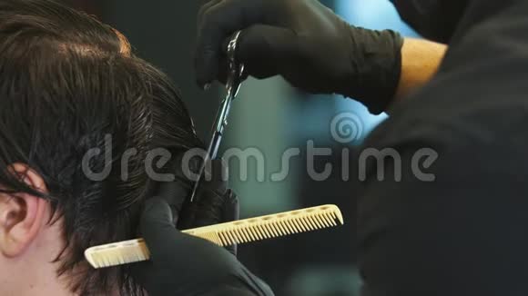 理发师用剪刀把客户湿头发贴在脑后视频的预览图