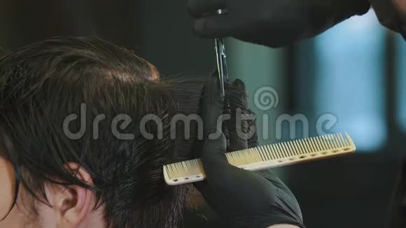 戴手套的理发师用一把薄剪刀把客户后湿发视频的预览图