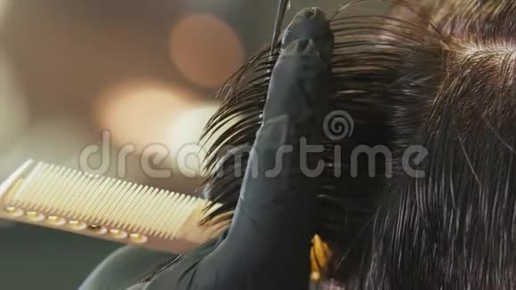 戴手套的理发师用把剪刀把客户的头发弄湿了视频的预览图