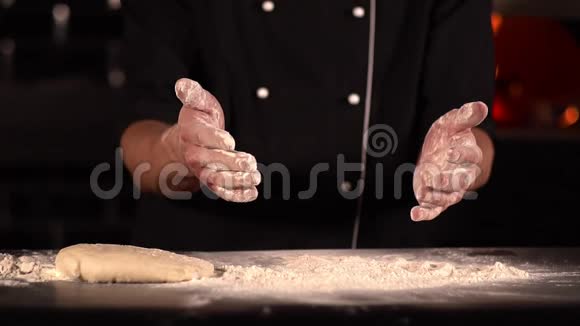 厨师把手从面粉上摇下来桌子上摆着比萨饼面团视频的预览图