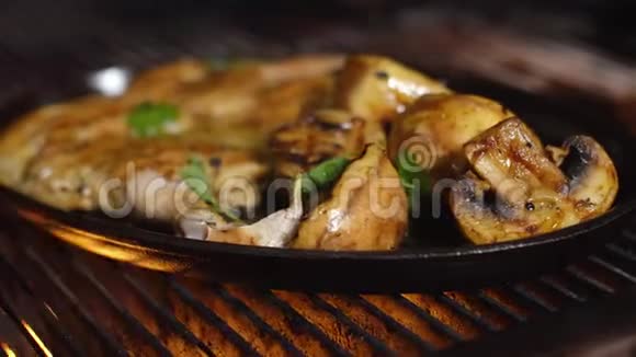 烤烟鸡配蘑菇和土豆放在烤架上的铸铁盘上视频的预览图