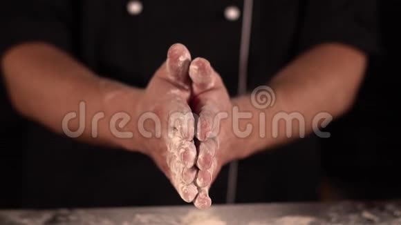 厨师用手拍打面粉把它们弄掉面粉碎屑的缓慢下落视频的预览图