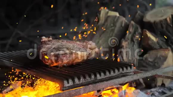 牛肉牛排是在烤架上用火花煮熟的牛肉排骨烧烤视频的预览图