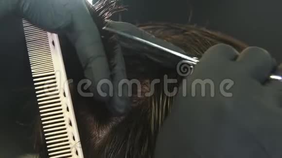 戴手套的理发师用剪刀剪客户头发湿了视频的预览图