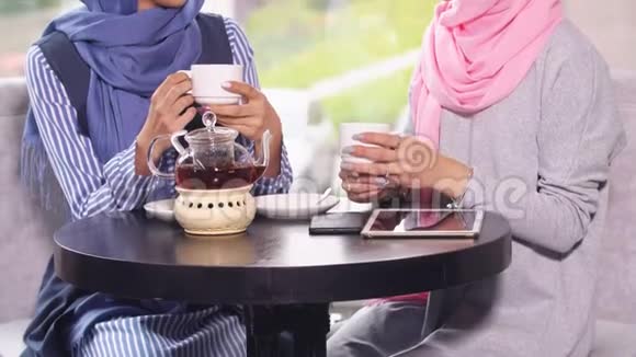 两位年轻漂亮的穆斯林商人在咖啡馆喝茶视频的预览图