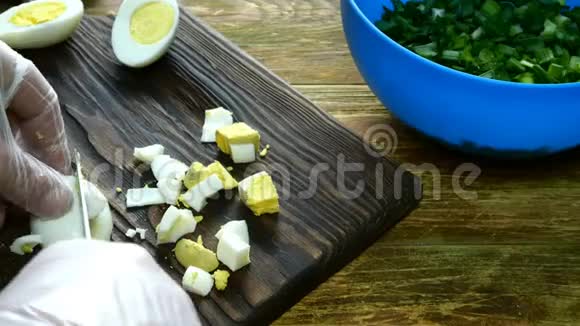 用青葱做春鸡蛋沙拉一步一步煮熟的鸡蛋在木制厨房板上切碎视频的预览图