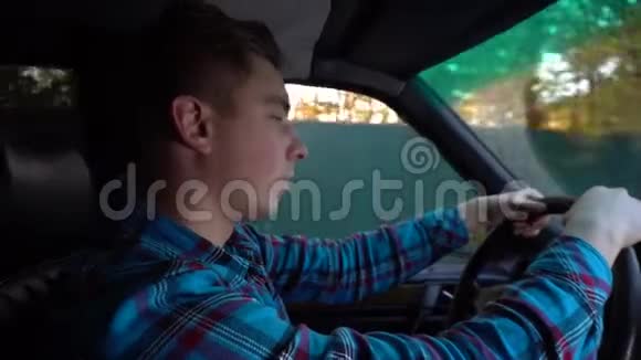 一个年轻人开着车睡着了白天的时间司机正在积极地挣扎着睡觉司机侧视频的预览图