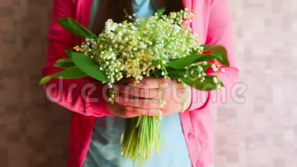女人带着百合花的山谷鲜花祝贺周年或生日快乐的概念视频的预览图