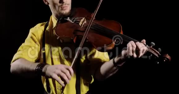男小提琴手在黑色背景上演奏ALT或小提琴乐器特写视频的预览图