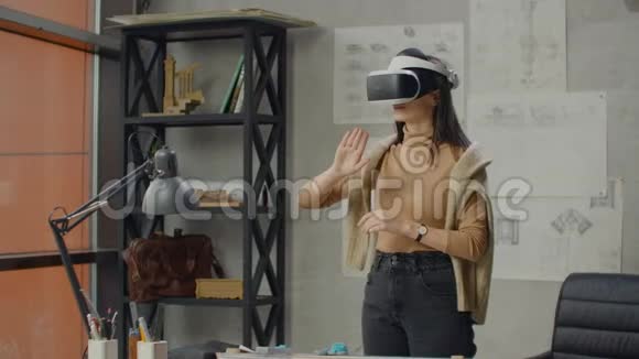 在虚拟现实头盔办公室里女建筑师用手势来管理一个项目而不离开办公室视频的预览图
