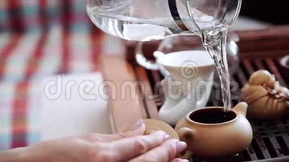 茶壶里放着茶叶倒着开水泡出芬芳可口的茶视频的预览图