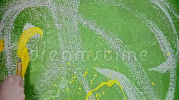 一个人用黄色的油漆在绿色的墙上写COLOR视频的预览图
