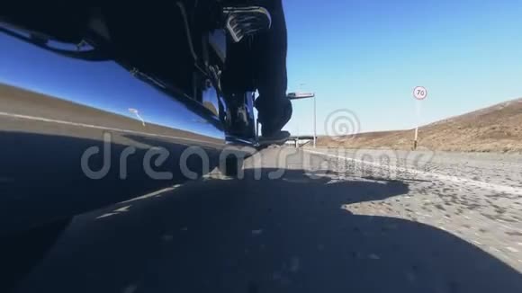 摩托车手骑在公路上在公路上投下阴影视频的预览图