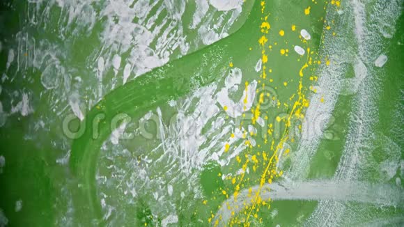 一个人在绿墙上溅出亮黄色的油漆视频的预览图