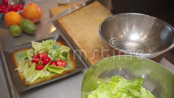 厨师把沙拉放在盘子里把奶酪撒在上面视频的预览图